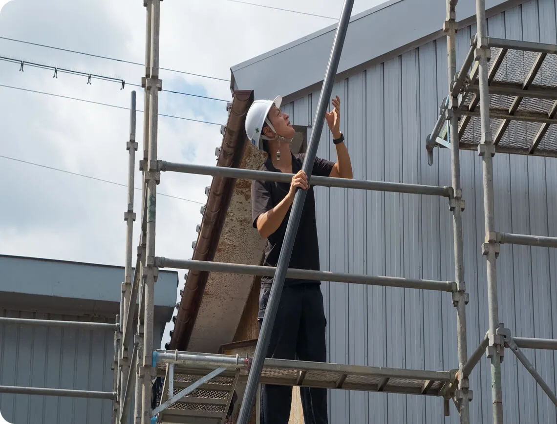 足場を組み立てるヘルメット姿の建設作業員