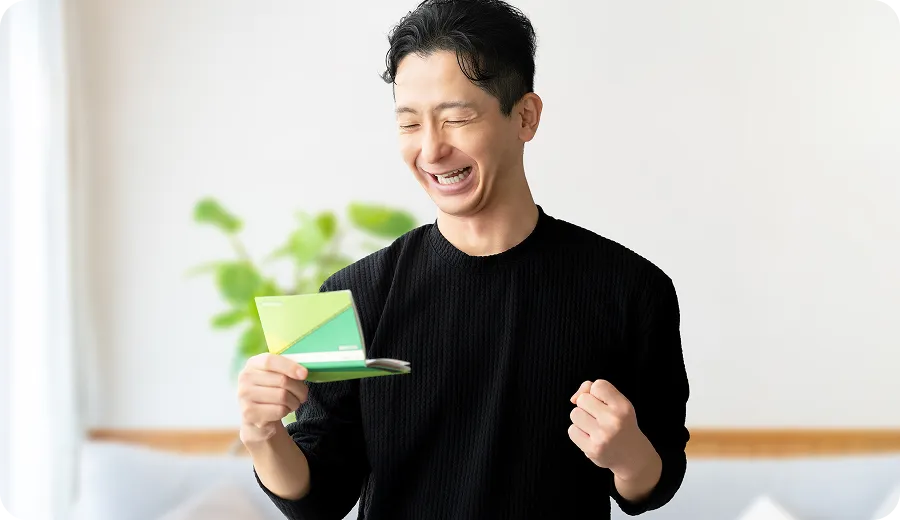 銀行口座の残高を見て喜ぶ男性