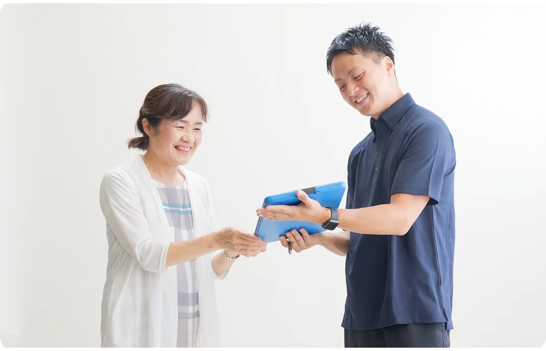 作業員がiPadを見せながらお客様に笑顔で説明しています