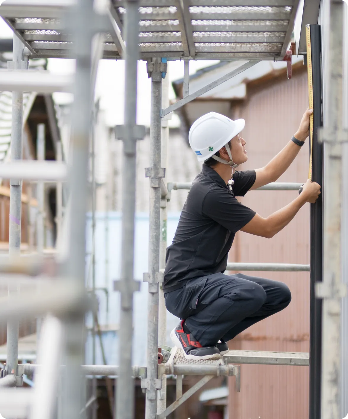 足場を組み雨樋の交換作業を行う作業員