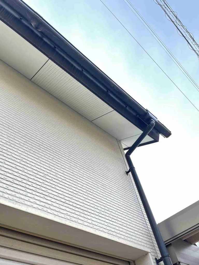 雨樋交換工事が完了し外壁の白と雨樋の黒のコントラストが美しい住宅の外観