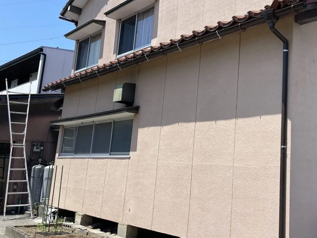 富山県富山市でベージュの外壁に合わせて茶色の雨樋と竪樋を新しく設置した施工後の外観