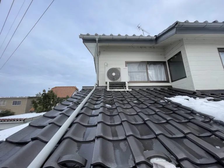 冬の積雪がある中でエアコン室外機周辺の排水経路を適切に配置した屋根