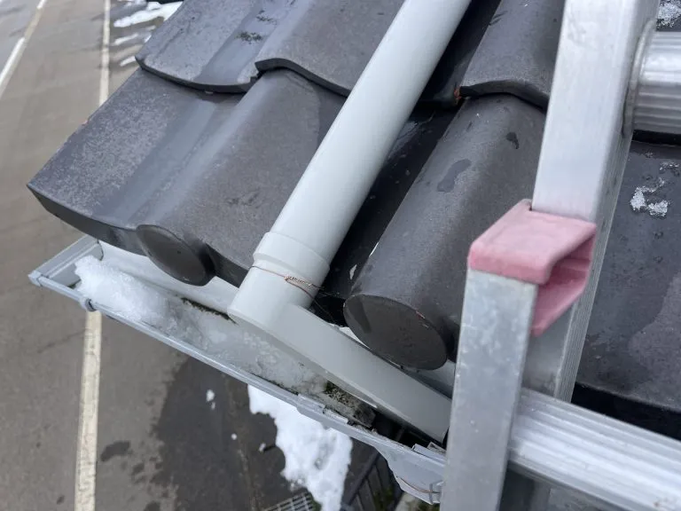 雪止め金具の近くで適切に排水できるよう調整して取り付けた新しい雨樋の接続部