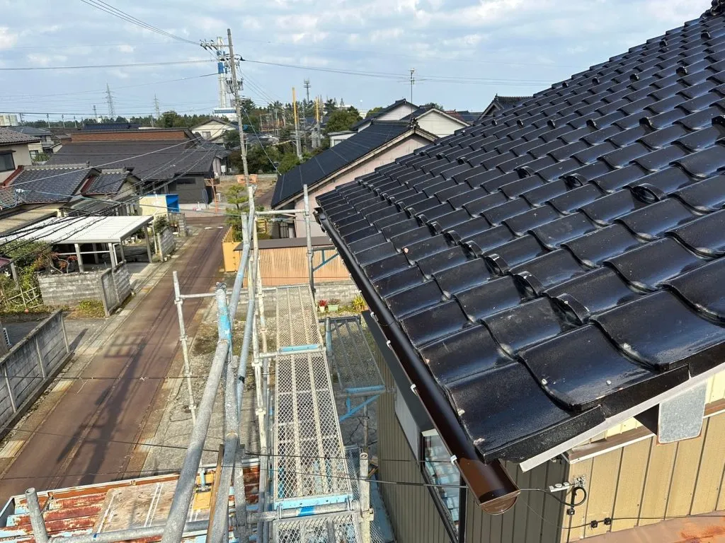 和風の瓦屋根に合わせて新しい茶色の雨樋を取り付けた施工後の様子