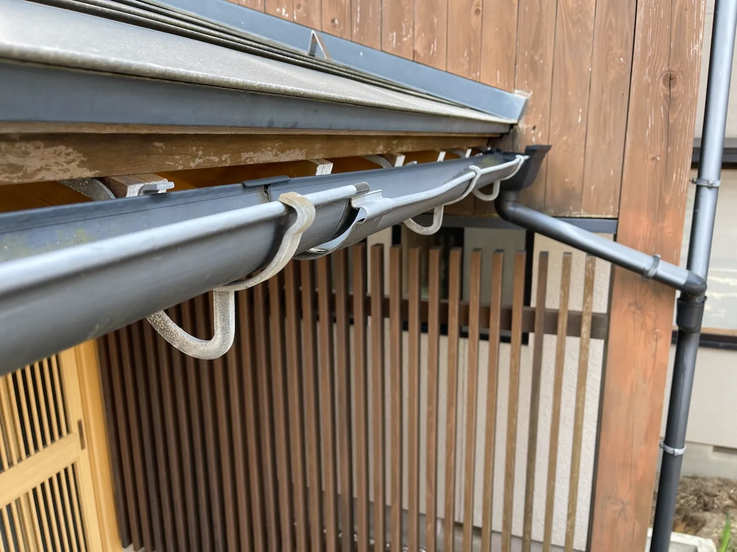 和風建築の軒先に取り付けられた経年劣化した施工前の雨樋の状態