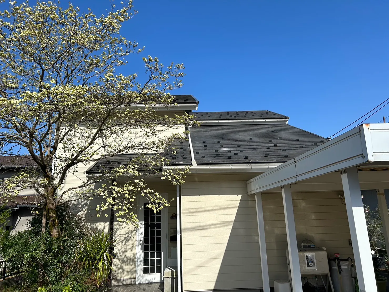 晴天の下に佇む新しい雨樋が取り付けられた施工後の大きな屋根の外観