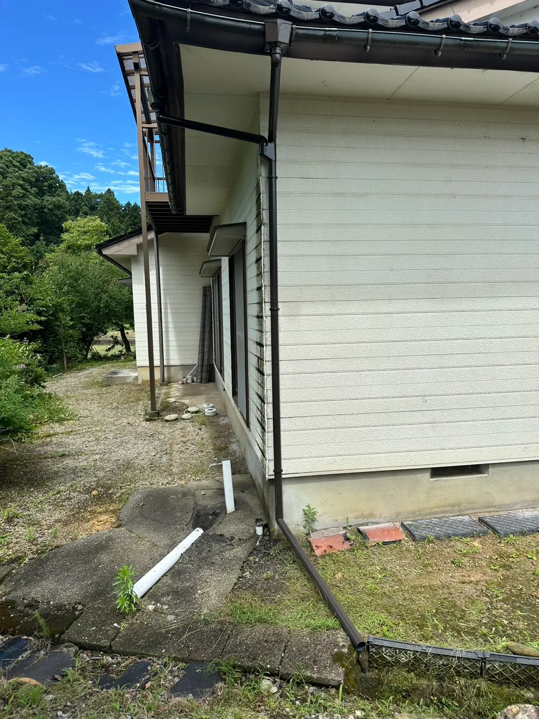 外壁を汚していた古い雨樋を撤去し新しいこげ茶色の竪樋へ交換した施工後の様子